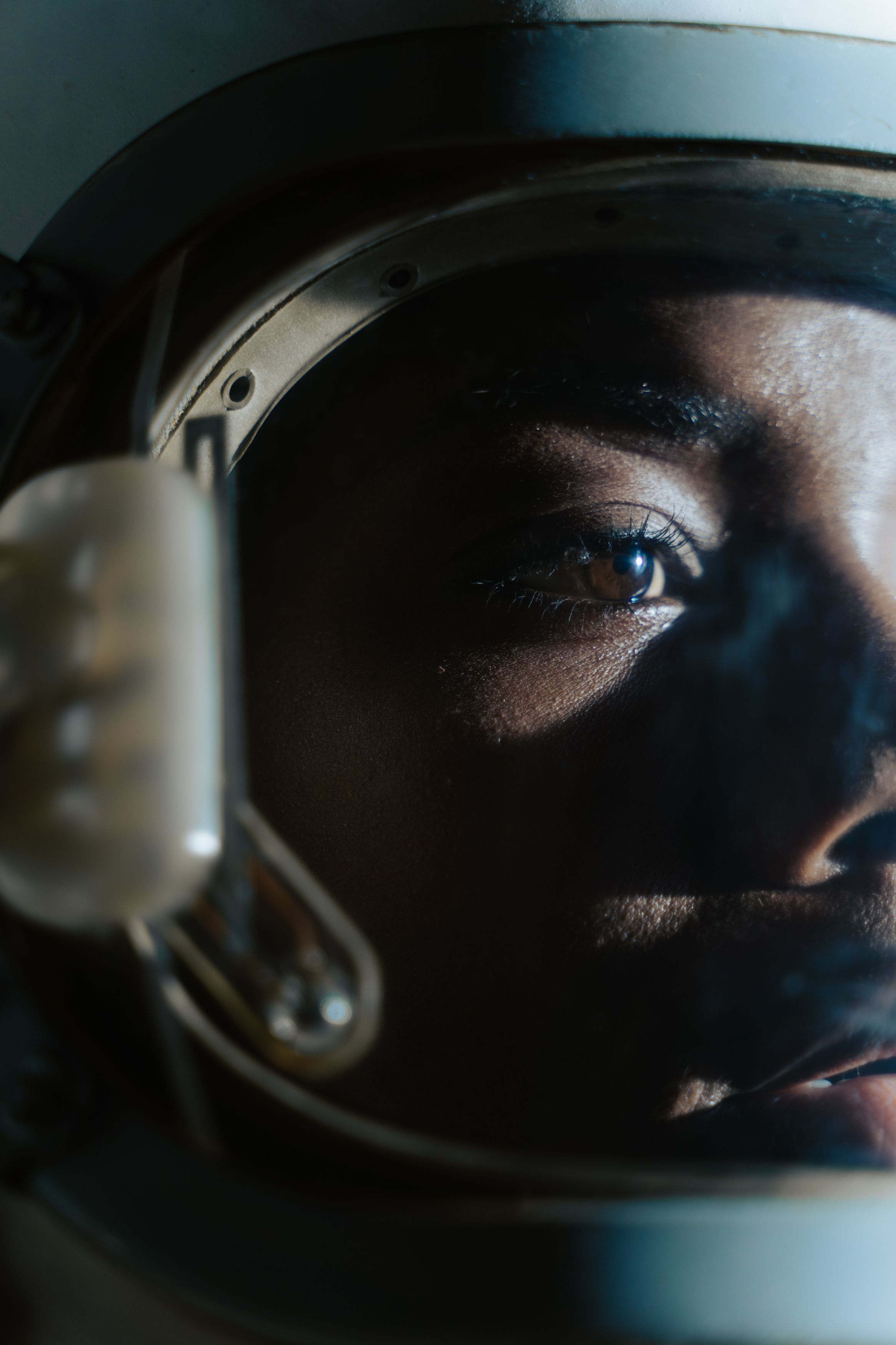 Close-up of a woman's face behind an astronaut helmet visor